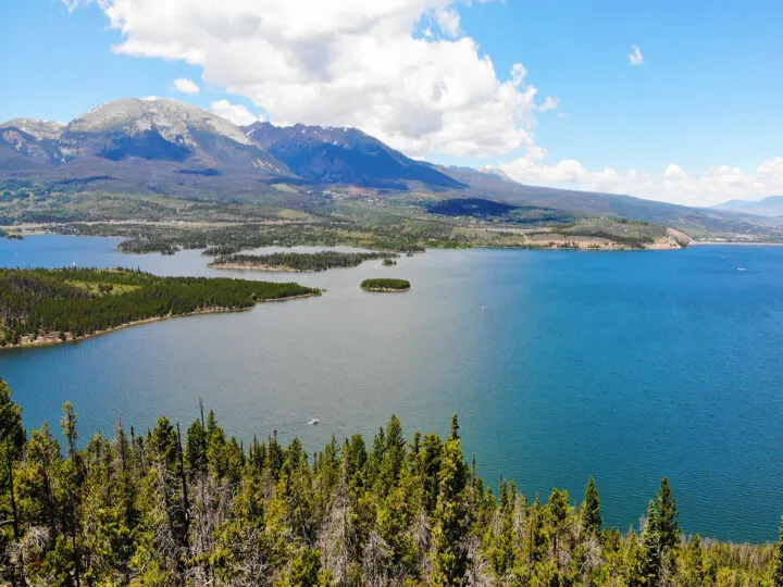 blue lake against Rocky Mountain peaks on a sunny day