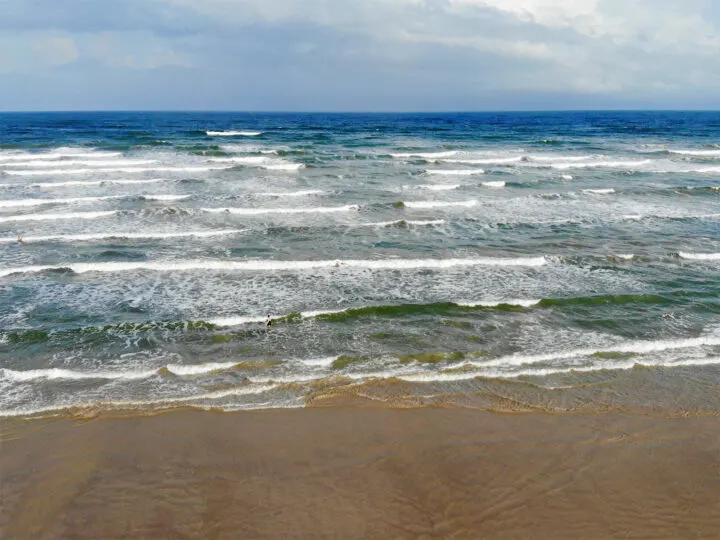 Texas beach from above lots of rushing waves on brown sandy beach