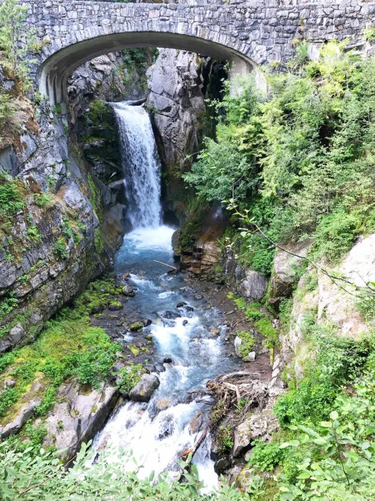 waterfall under bridge with trees beside it top things to do in mt rainier