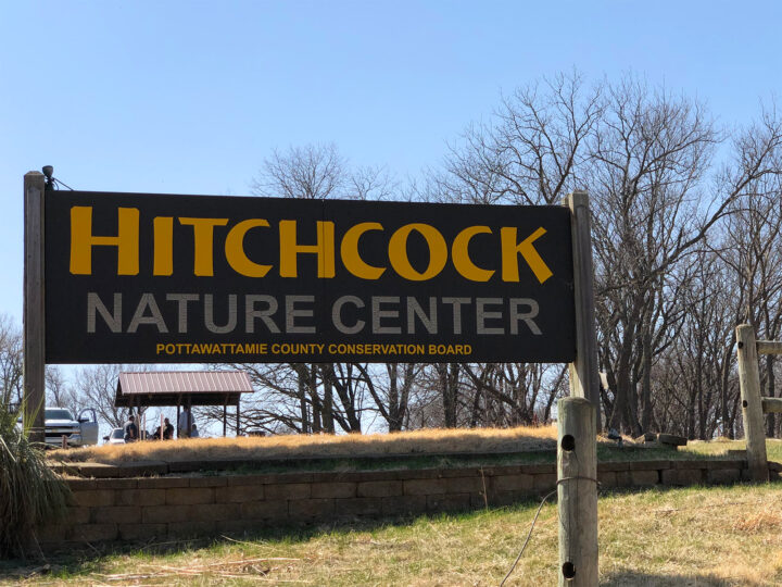 Hitchcock nature center sign on a sunny day with dormant trees in background