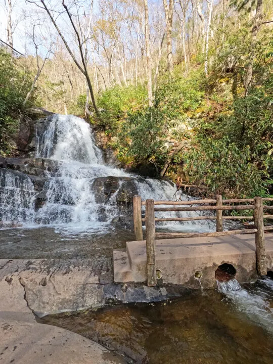 Laurel Falls view of bridge in front of waterfall with sunny hillside