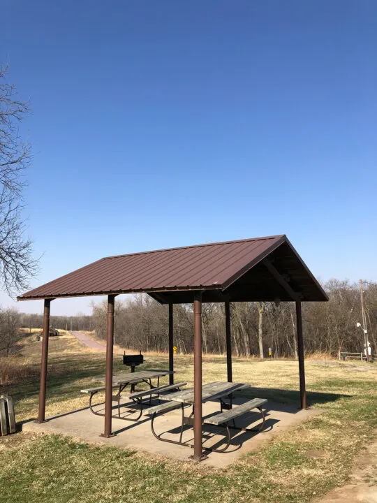 picnic pavilion with two tables and park in background