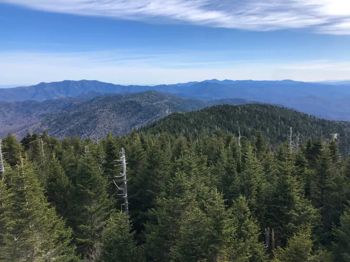 view of the smoky mountains green treetops and rolling hills on sunny day during RV travel USA