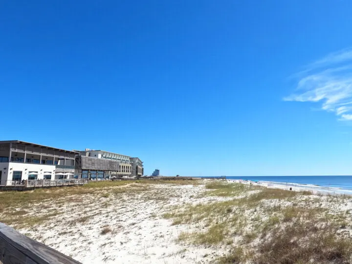the lodge at Gulf State Park in the distance with puffy sand dunes in foreground