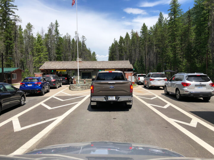 entrance of glacier national park with 3 rows of cars waiting