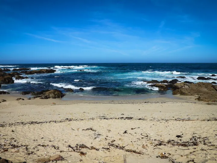 view of beach from straight on tan sand blue water white waves