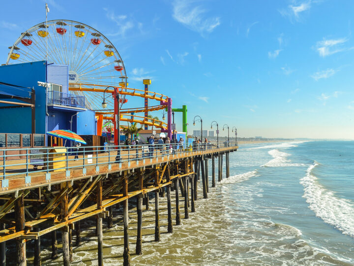 view of pier with carnival rides and ocean waves