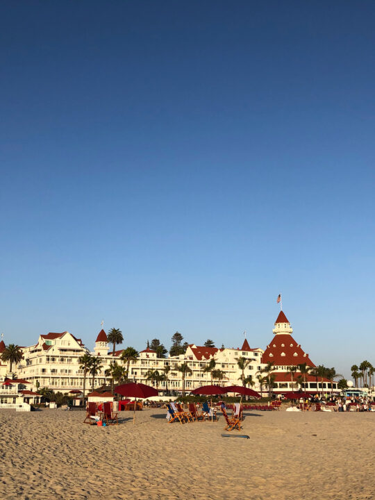 red and white hotel on beach with blue sky