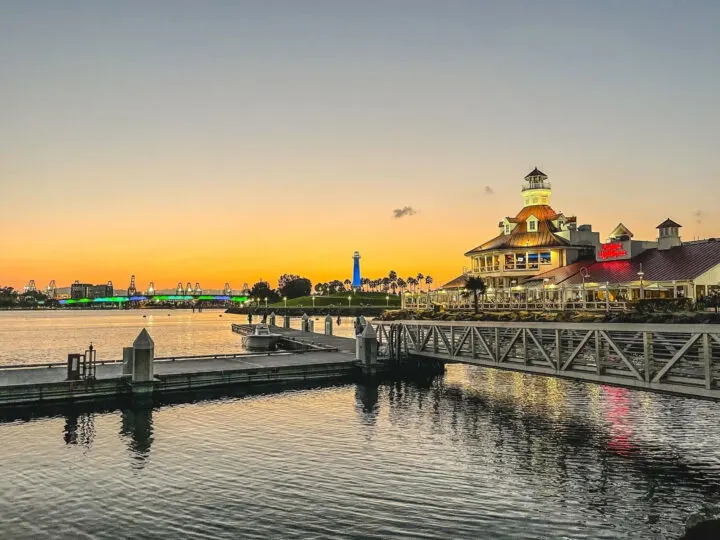 San Francisco to San Diego road trip view of Long Beach boardwalk with restaurant and palm trees at dusk