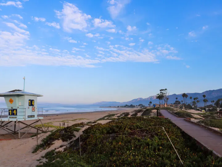 california coast road trip view of beach and mountains in distance at sunset