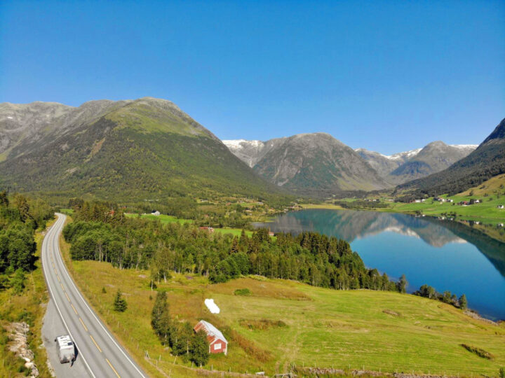 adventure bucket list driving western fjords view of road lake and mountains on sunny day