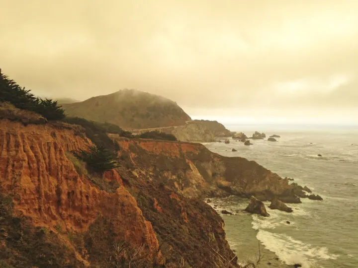 california pacific coast highway in fog rugged cliffs with water below