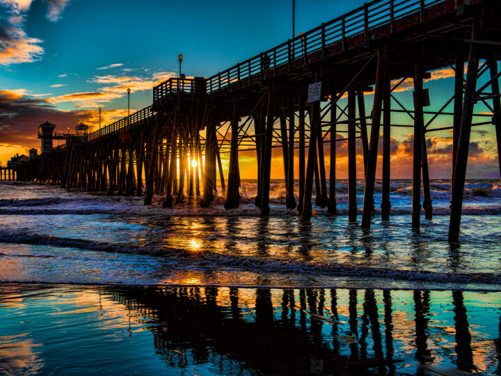 colorful sunset with ocean and pier in foreground along a San Francisco to San Diego road trip