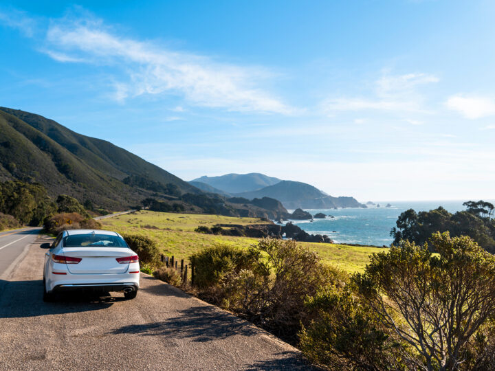 california coast road trip car on side of road with coast and ocean in distance