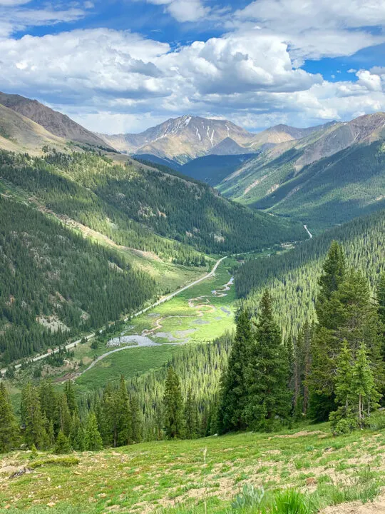 views of the colorado drives with valley and green trees with mountain peaks in the distance