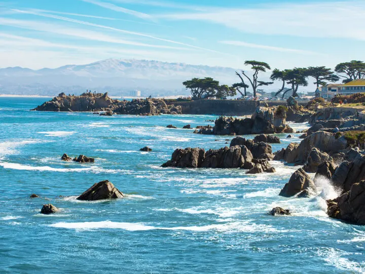 CA pacific coast highway views of rocks in water with trees and mountain in distance