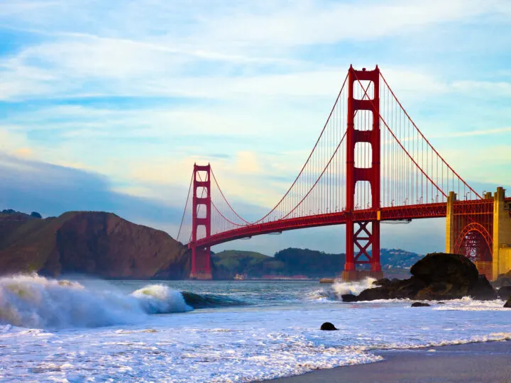 San Francisco bridge with cliffs in background white waves and large bridge