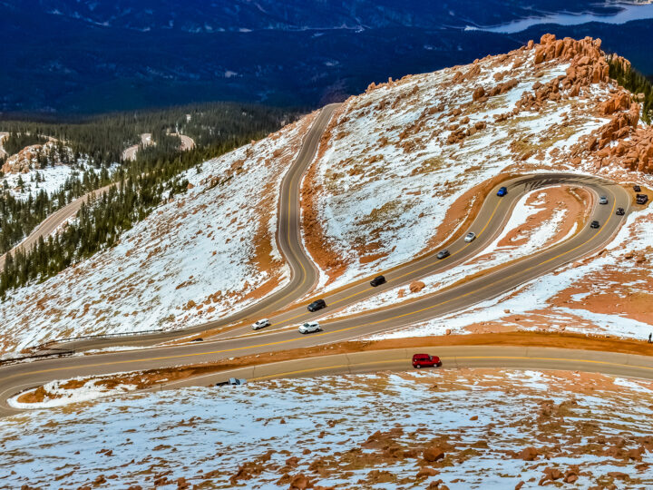 looking down mountain at curvy road with snow
