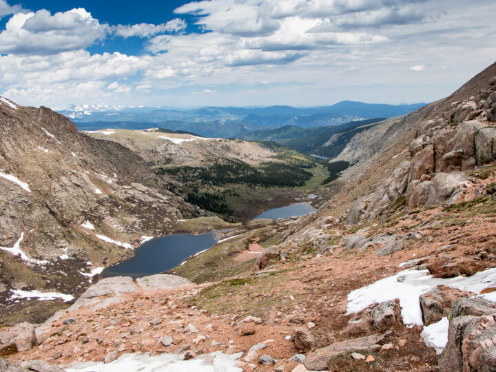 mount evans scenic byway view of rocky cliffs with lake and mountains in the distance