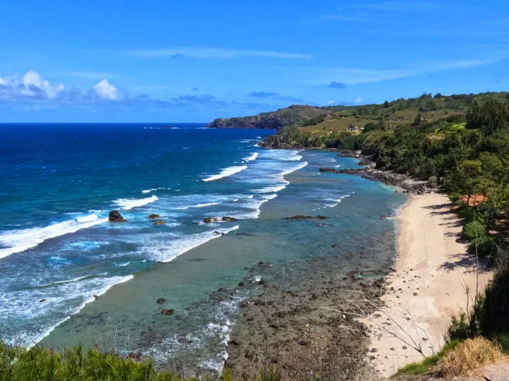 Punalau Beach from above sand rocky shore white waves blue ocean