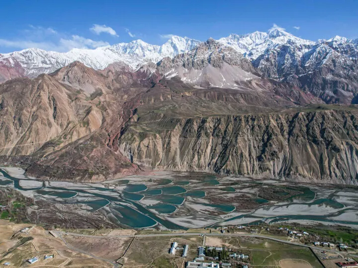 adventure bucket list view of Pakistan mountains with fields below