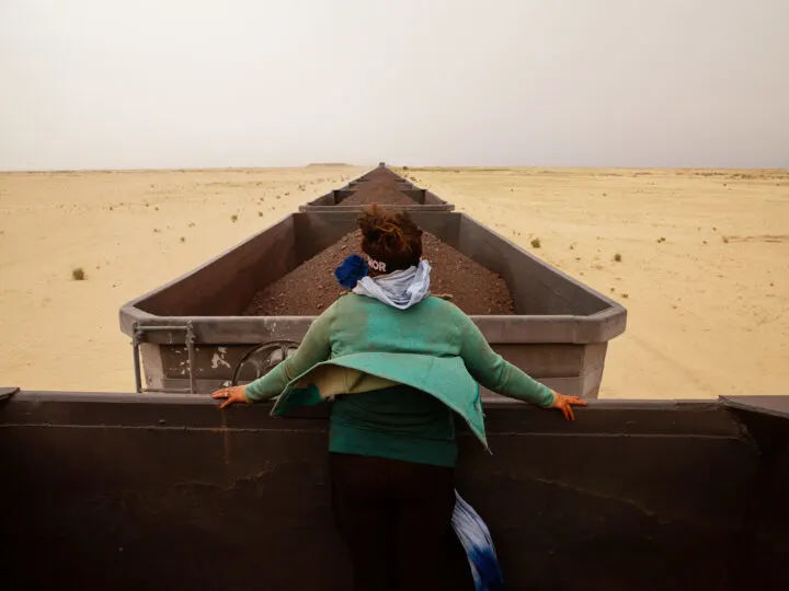 adventurous bucket list woman hitchhiking on a train while standing in train cart looking in distance