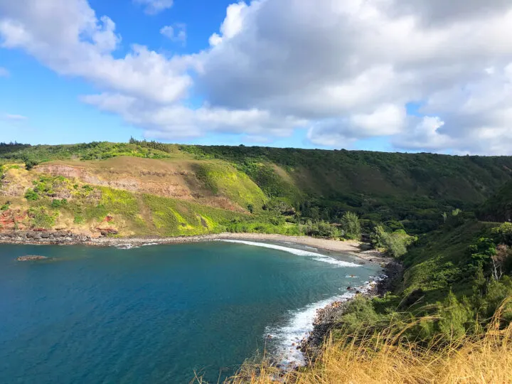 west maui mountains beach view of cove with blue water sandy beach surrounded by lush hills