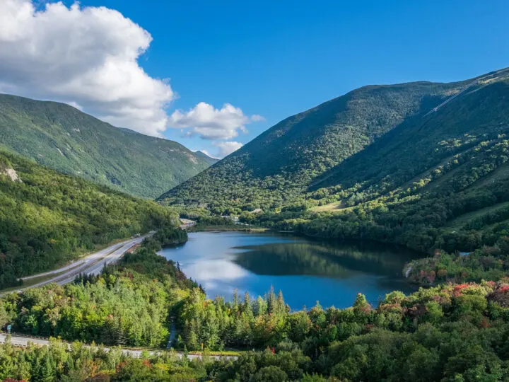 Places to visit in September in USA view of New Hampshire mountains with lake and road