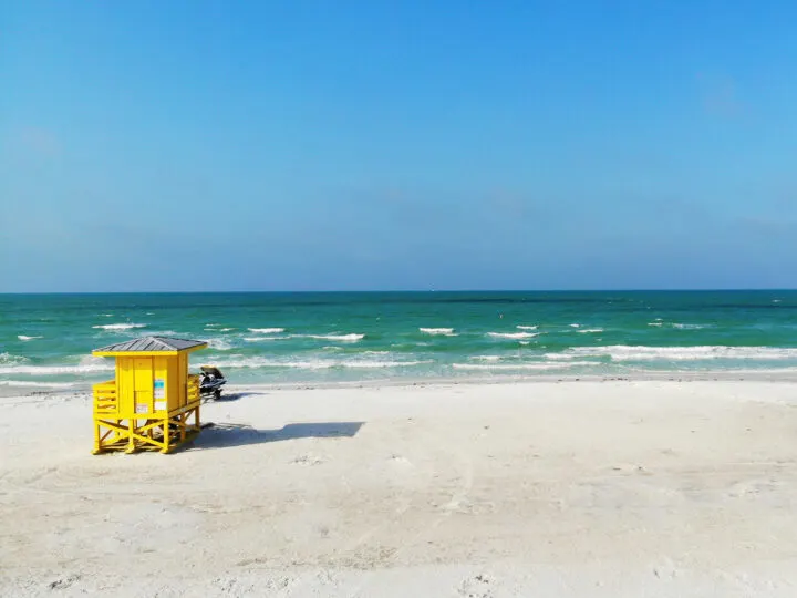 view of yellow lifeguard stand with teal ocean in distance in Florida