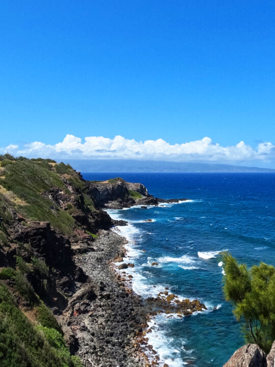 rocky coastline with black sand beach white waves blue ocean