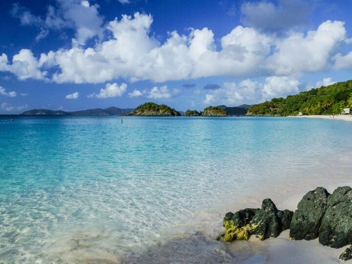 teal and blue water with beach and mountains in distance USVI national park in October