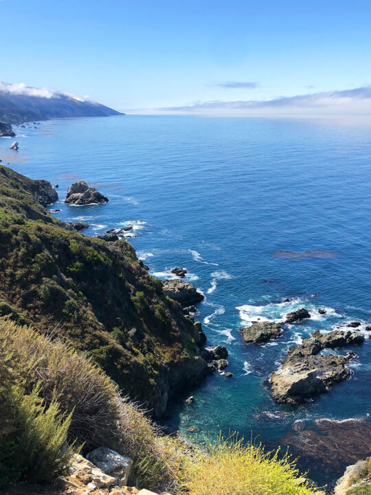 view of Big Sur california vibrant blue water with rocky cliffs