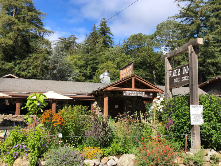river inn Big Sur hotels view of building roof with flowers out front trees behind