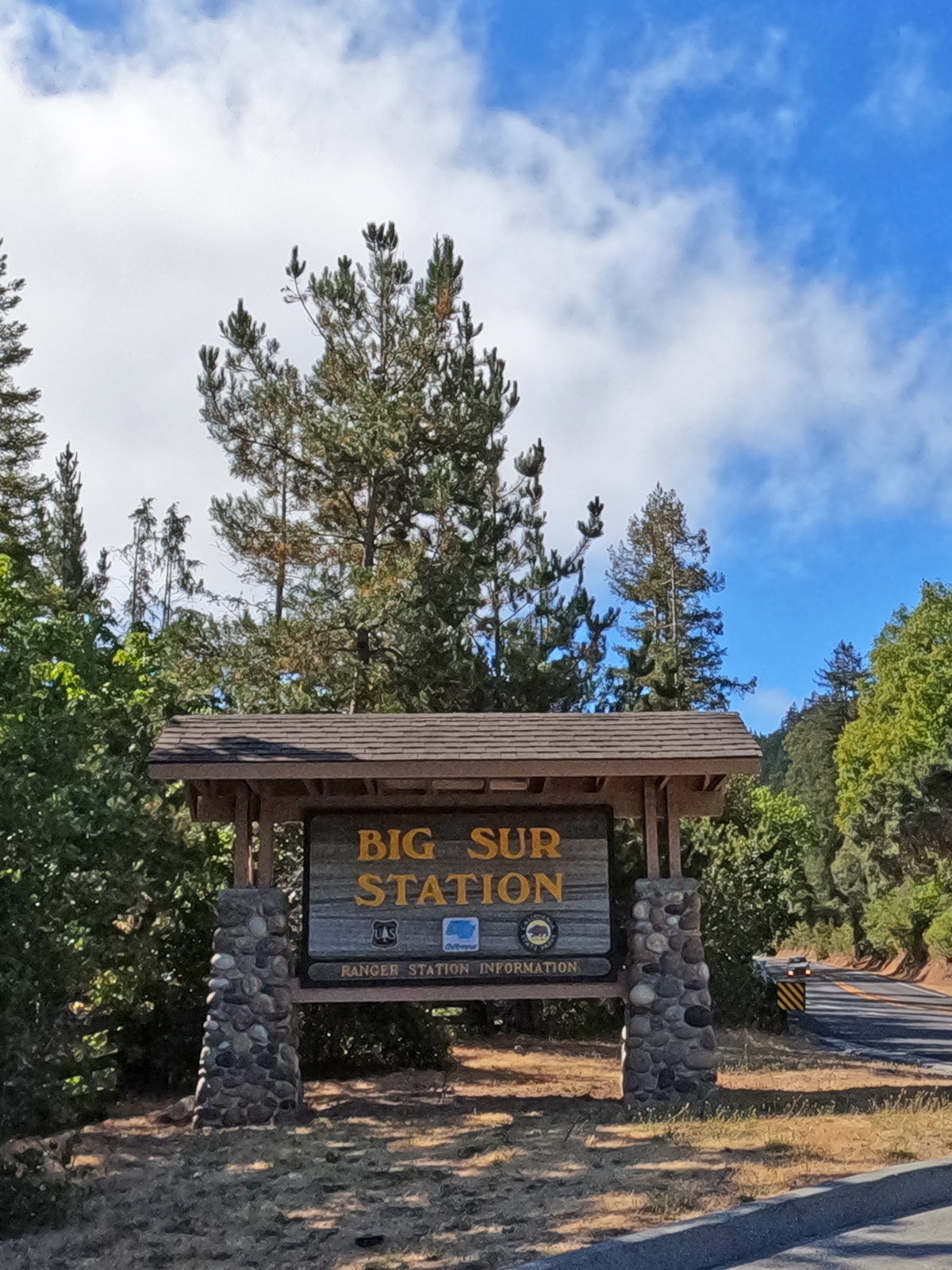 Big Sur station sign with trees behind on sunny day