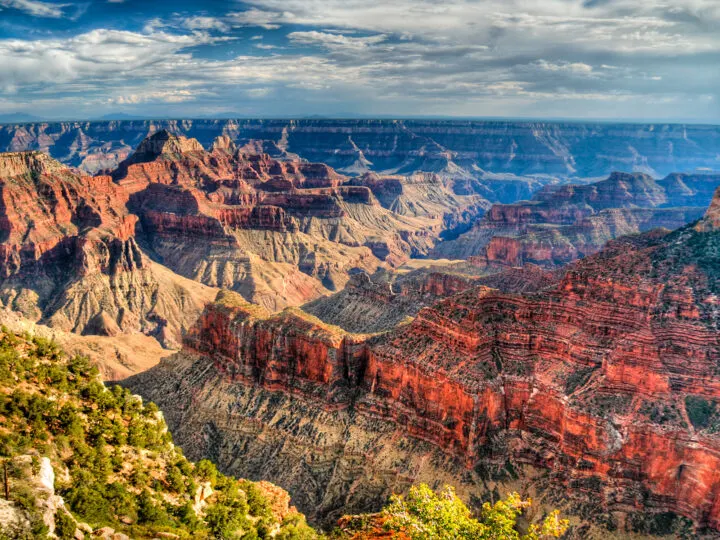 best national parks to visit in March views of the Grand Canyon landscapes of red grey and tan canyon on partly cloudy sky