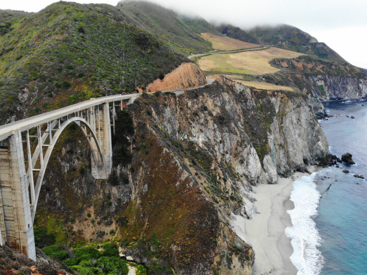 Big Sur bridge view of bridge with arch under and ocean with waves along rugged coastline