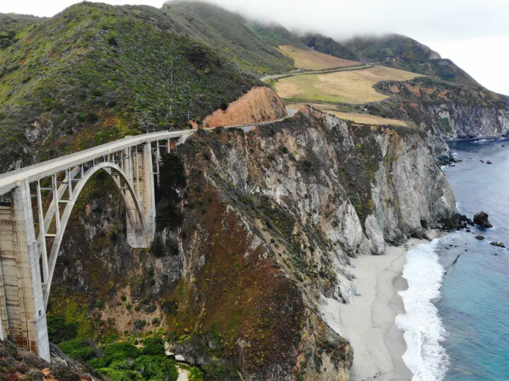Pacific coast highwaybridge view of bridge with arch under and ocean with waves along rugged coastline