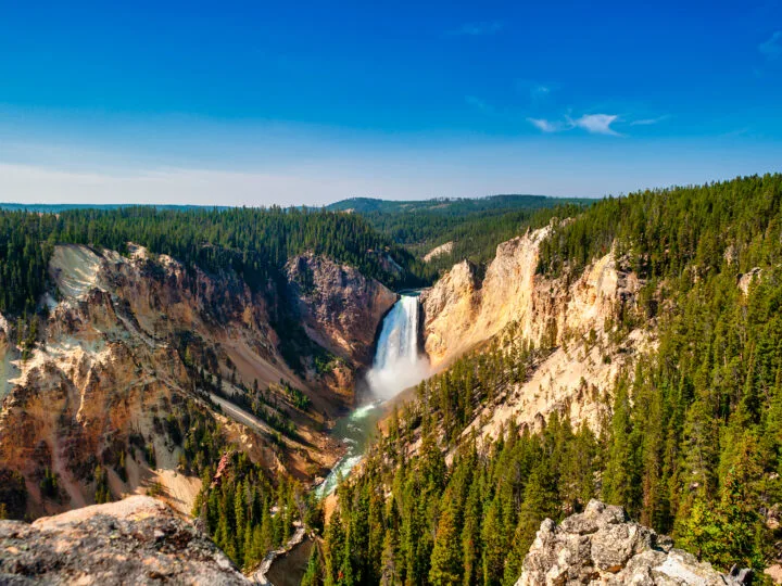 lower falls Yellowstone large canyon waterfall with trees yellow rocks blue sky
