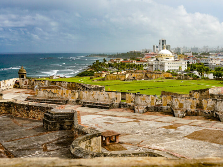 Warm places to visit in December in USA Best winter sun destinations Warm places to visit in USA in December Warmest place in US in December view of Puerto Rico ruins ocean and city in distance