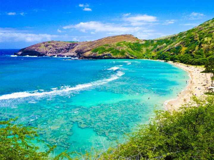 warm places to visit in USA in December view of teal water beach along hillside