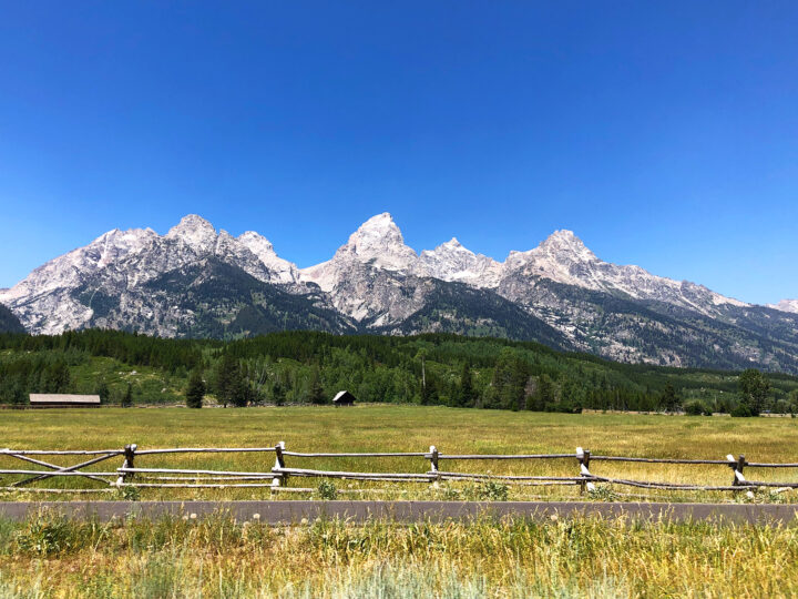 grand teton hikes fence and field with teton mountains in background
