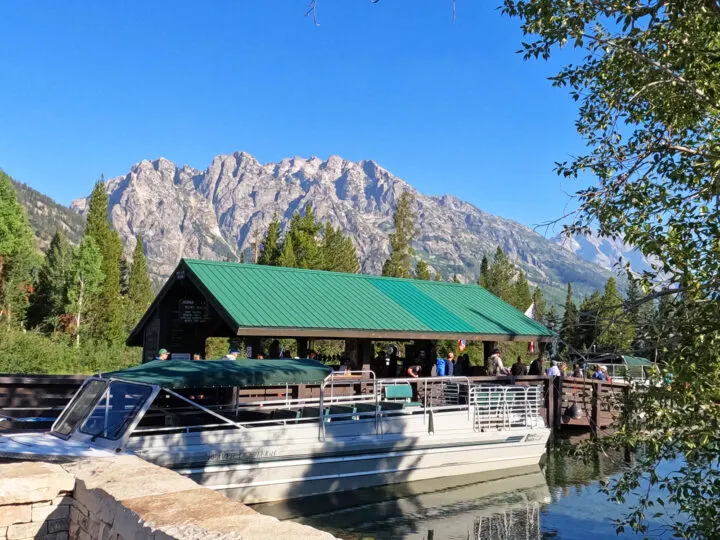 Jenny lake boat shuttle view of dock with boat and mountain in distance