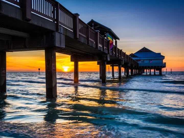 sunset behind pier on ocean