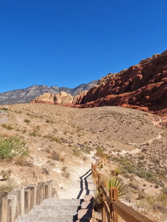 red rock scenic loop hiking trail into desert with red rocks in distance