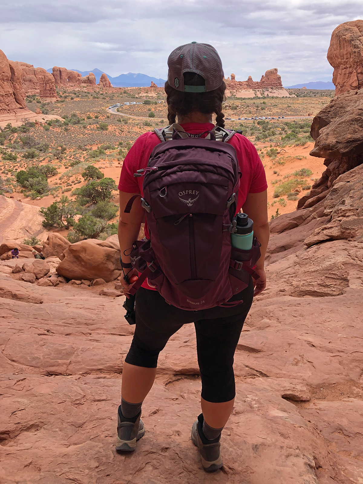 woman standing with backpack with rocky spires in distance