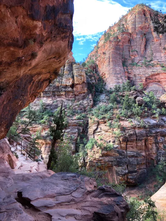 canyon overlook trail view of hiking trail with ledge in distance and massive canyon wall