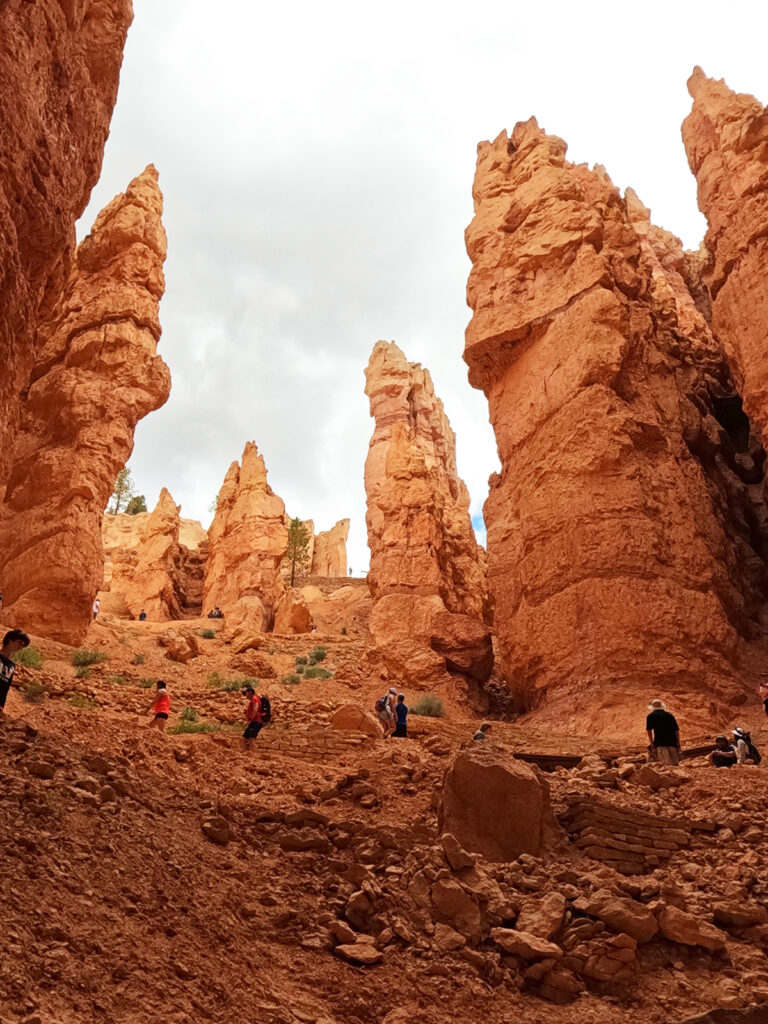Bryce Canyon Wall Street hike view looking up into canyon at orange rocky spires and people hiking