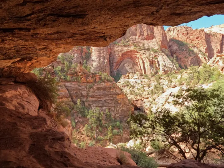 canyon overlook Zion National park view of hiking trail through cave with view of canyon