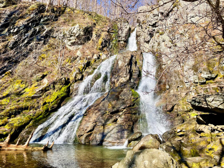 best national parks to visit in may view of waterfall and mossy rock hillside with trees