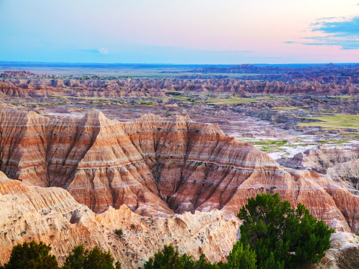badlands national park in spring view of jagged rocky spires multicolored with sunset in distnace